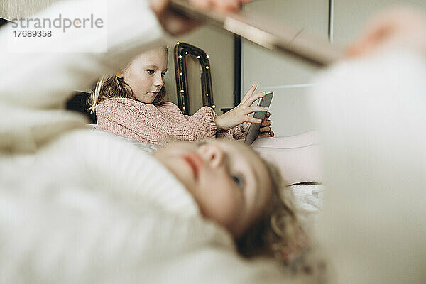 Mädchen benutzen Smartphones im Schlafzimmer zu Hause