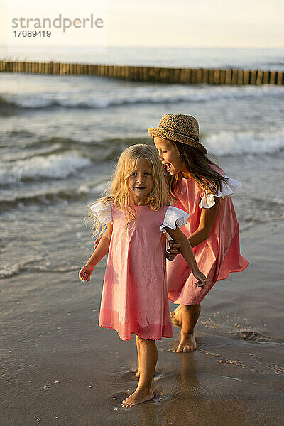 Glückliche Geschwister  die zusammen am Strand spielen