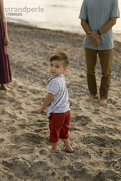 Baby Junge mit Eltern am Strand