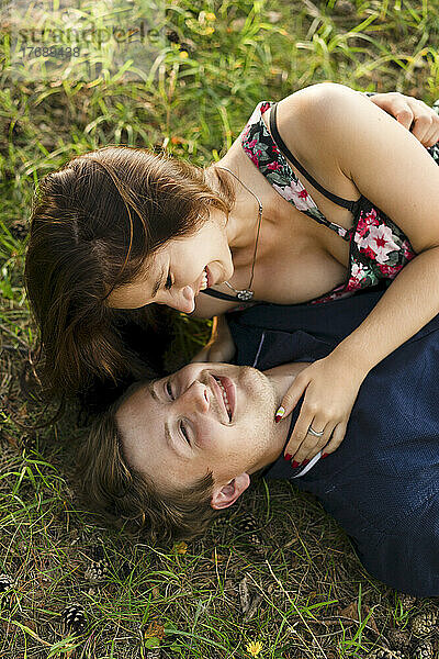 Glückliches junges Paar  das auf Gras liegt
