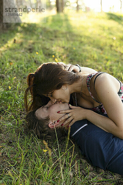 Glückliches Paar  das sich küsst und im Gras liegt