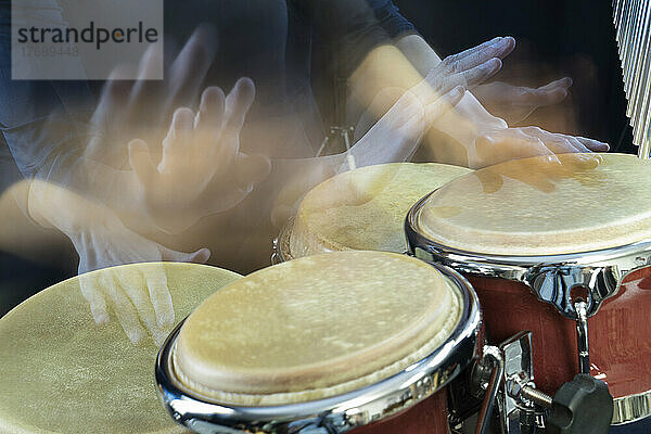Hands of woman playing bongo
