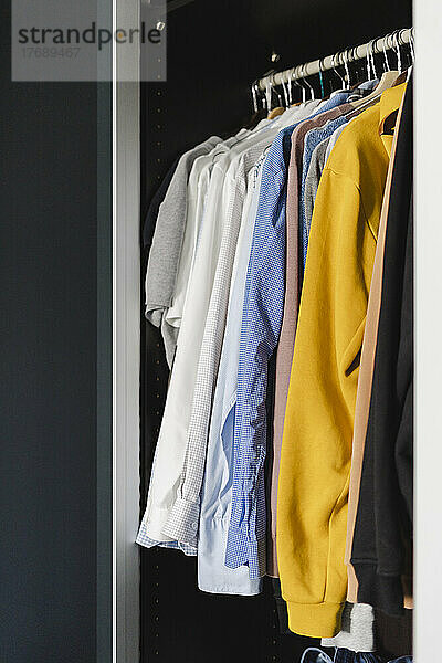 Kleidung im Schrank zu Hause arrangiert