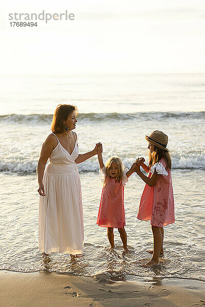 Glückliche Mutter und Töchter  die Spaß am Strand haben