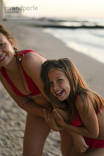 Glückliche Mutter und Tochter  die Spaß am Strand haben