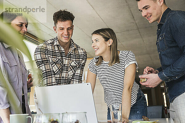Junge Geschäftsleute teilen sich Laptop im Büro