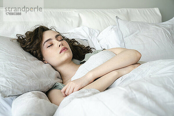 Schöne junge Frau  die zu Hause im Bett schläft