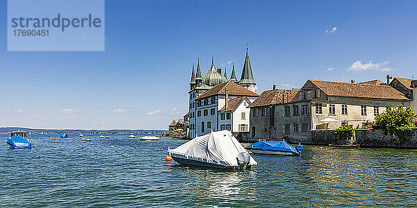 Schweiz  Thurgau  Steckborn  in Schrumpffolie verpackte Boote schwimmen am Bodenseeufer mit Stadthäusern im Hintergrund