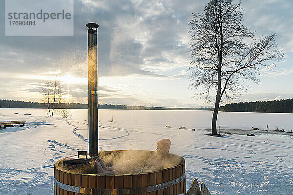 Frau nimmt im Winter ein Bad im Whirlpool