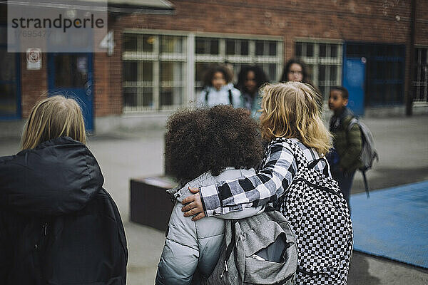 10-11 Jahre  arm runt  bakifrån  Barn  barndom  blandad härkomst  blandat ursprung  blont hår  campus  tag  Europa  flickor  fotografi  fritid  färgbild  gemenskap  grundschule  gå  halvkropp  horisontell  und förgrunde  innan tonåren  Liggande  lockigt hår  oidentifierbara personer  Osorterade  pojkar  promenera  ryggsäck  Skandinavien  skolbarn  skolflicka  skolgård  skolpojke  student  Sverige  tre människor  Three personer  utbildning  utomhus  varma kläder  vita personer  vänskap