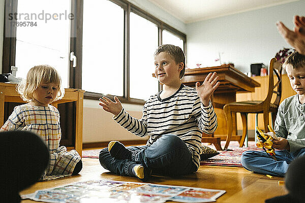 Junge mit Down-Syndrom vervollständigt Puzzle  während er mit seiner Familie im Wohnzimmer sitzt
