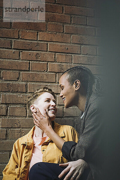 Romantisches homosexuelles Paar  das sich gegenseitig an einer Mauer betrachtet