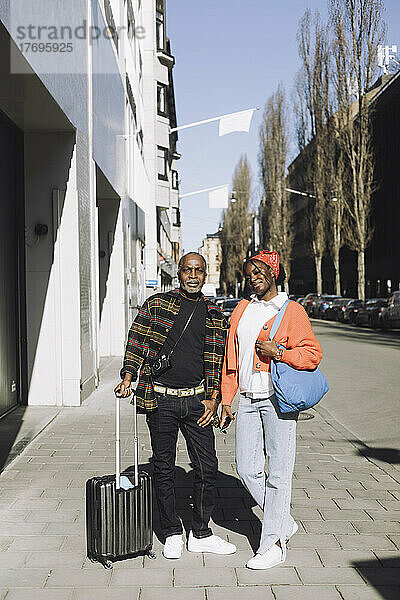 Ganzkörperporträt von Vater und Tochter auf einem Fußweg an einem sonnigen Tag