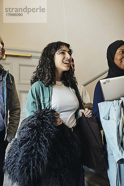 Lächelnde Studentin mit Freunden in der Universität