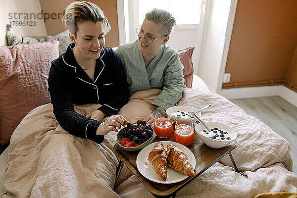 Lesbisches Paar genießt das Frühstück im Bett zu Hause