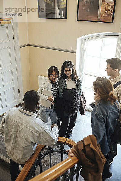 Hohe Winkel Ansicht der multirassischen Studenten im Gespräch an der Treppe in der Universität