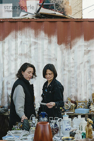 Lesbisches Paar kauft Geschirr an einem Marktstand