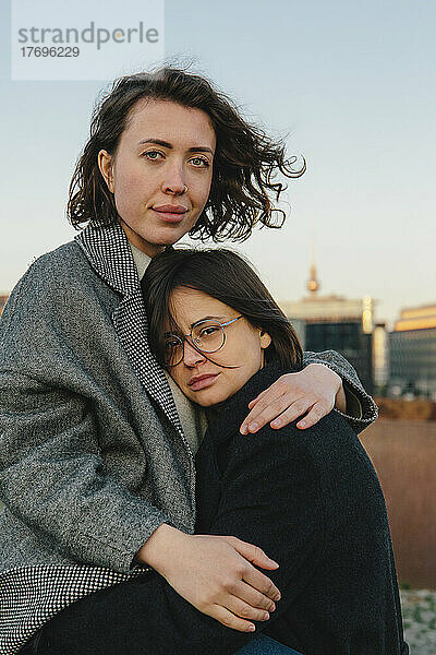 Porträt eines lesbischen Paares  das sich auf einem Dach umarmt
