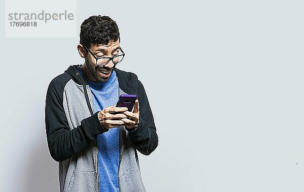 Person lächelnd und mit Handy isoliert  Person mit Brille lächelnd mit Smartphone auf isolierten Hintergrund  Mann mit Brille lächelnd am Handy isoliert