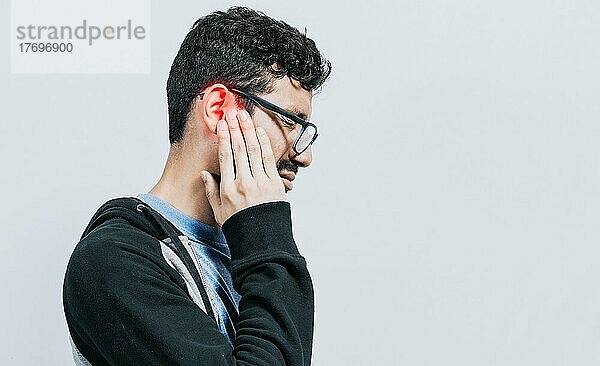 Konzept der Person mit Otitis und Tinnitus  Person mit Ohrenschmerzen  auf isoliertem Hintergrund  Leidender Mann massiert sein Ohr isoliert