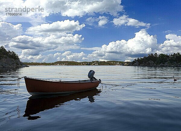 Kleines Holzboot in der Mitte eines Sees  Einsames Holzboot im Wasser  isoliertes Holzboot  Draufsicht auf ein kleines weißes Holzboot in der Mitte eines Sees