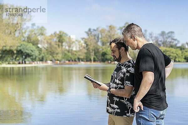 Ein paar reife Männer lesen in einem See  mit einer glücklichen und entspannten Einstellung