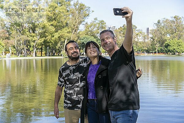 Eine Gruppe von Freunden unterschiedlichen Alters macht ein Selfie in einem See. Fröhliche Ausdrücke. Platz kopieren