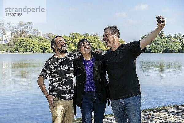 Eine Gruppe von Freunden unterschiedlichen Alters macht ein Selfie in einem See. Fröhliche Ausdrücke. Platz kopieren