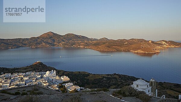 Morgenlicht  Golf von Milos  fast spiegelglattes Meer  hellblauer Himmel  Profitis Elias  Kapelle Panagia Thalassitra  Häuser  Plaka  Insel Milos  Kykladen  Griechenland  Europa