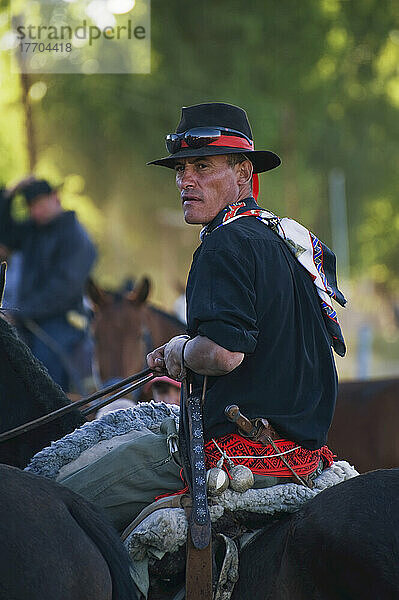 Ein Mann mit Hut  Schal und buntem Gürtel auf einem Pferd sitzend; Malargue  Argentinien