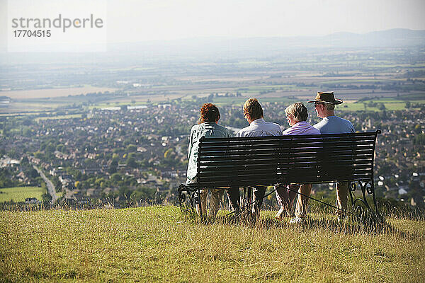 Ausruhen auf einer Bank und Bewunderung der Aussicht am Cleeve Hill  dem höchsten Punkt in den Cotswolds auf dem berühmten 100-Meilen-Weg des Cotswold Way oberhalb von Cheltenham; Gloucestershire  England