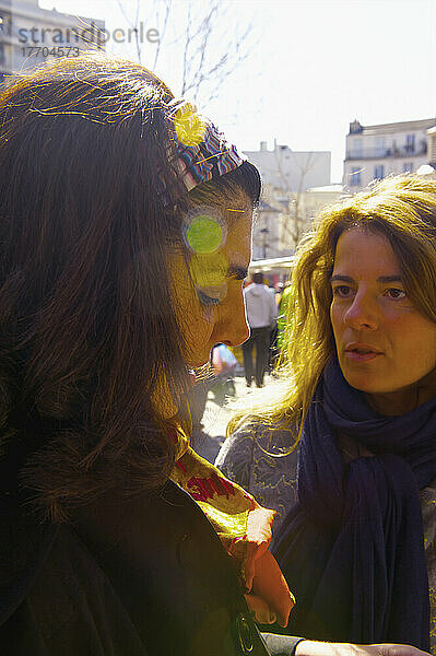 Freunde im Gespräch mit Sonnenlicht auf ihren Gesichtern; Paris  Frankreich