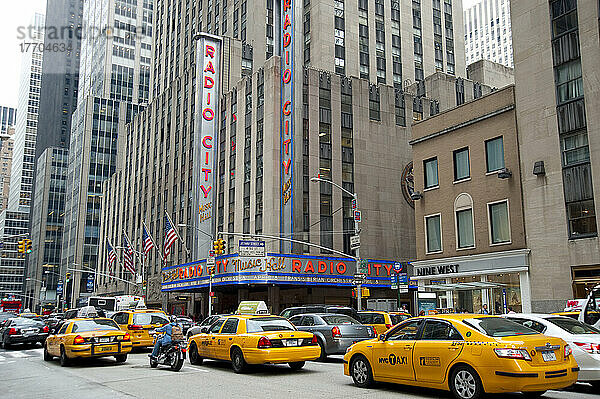 Taxis  die an der Radio City Music Hall vorbeifahren  einem berühmten Unterhaltungszentrum im Rockefeller Center  Midtown Manhattan  New York  USA