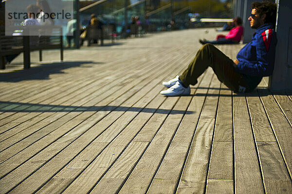 Menschen entspannt auf einer hölzernen Promenade; Barcelona  Spanien
