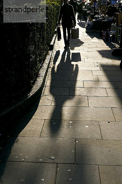 Geschäftsmann auf der Portobello Road bei Sonnenaufgang; London  England