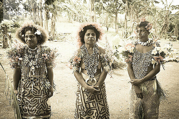 Dorfmädchen in Kleidern aus Tapa-Rindenstoff bereiten sich auf die Aufführung eines traditionellen melanesischen Stammestanzes im Dorf Natade in den Tufi-Fjorden von Cape Nelson in der Oro-Provinz von Papua-Neuguinea vor; Tufi  Oro-Provinz  Papua-Neuguinea