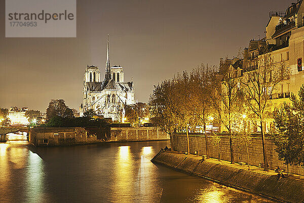 Lichter erhellen den Fluss mit einer beleuchteten Kirche im Hintergrund; Paris  Frankreich