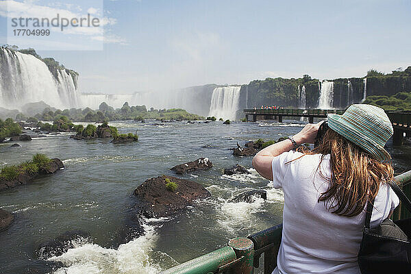 Ein Tourist fotografiert die Wasserfälle im Iguacu-Nationalpark; Brasilien