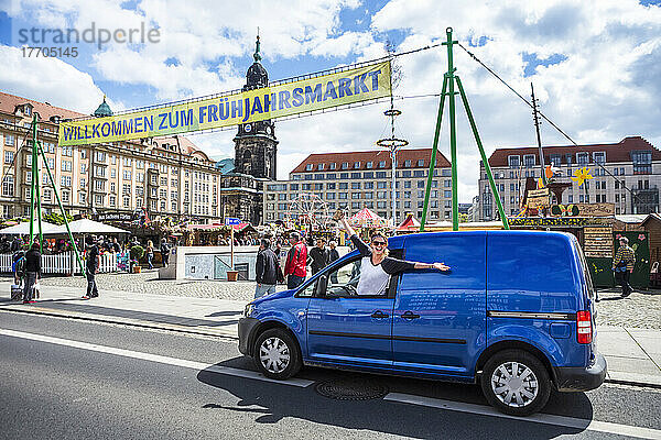 Frau hängt mit ausgestreckten Armen aus dem Autofenster und freut sich auf dem Altmarkt über ein Fest auf dem Dresdner Frühlingsmarkt; Dresden  Sachsen  Deutschland