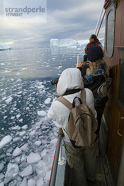 Besucher auf einer Mitternachtsfahrt durch den Ilulissat-Eisfjord  eine der Unesco-Welterbestätten. Grönland.