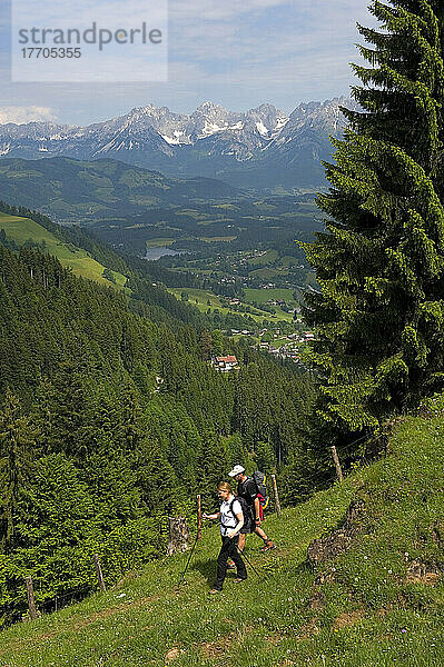 Ein wanderndes Paar in der Kitzbüheler Alpenregion mit dem Gebirgskamm des Wilden Kaisers im Hintergrund. Tirol  Österreich.