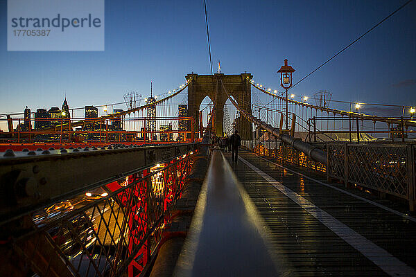 Fußgängerweg auf der Brooklyn Bridge in Richtung Manhattan bei Nacht; New York City  New York  Vereinigte Staaten von Amerika