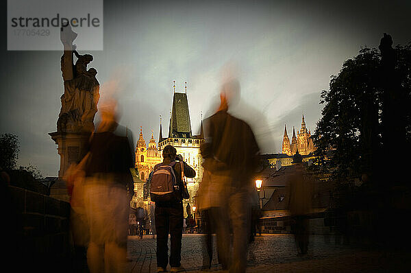 Langzeitbelichtung von Menschen stehen auf der Karlsbrücke in der Abenddämmerung; Prag  Tschechische Republik