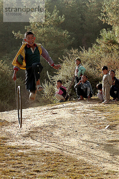 Einheimische Kinder aus Paro spielen mit Reifen am Stadtrand von Paro. Foto: Jill Mead Axiom Nov 2003