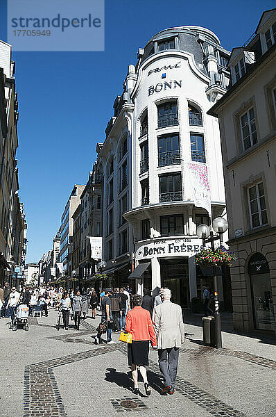 Fußgänger  die eine schmale Straße zwischen Geschäftsgebäuden entlanggehen; Luxemburg