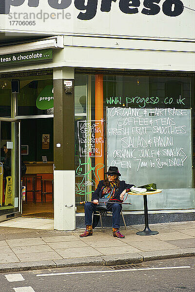 Ein Mann sitzt an einem Tisch außerhalb eines Cafés  Portobello Road Market; London  England