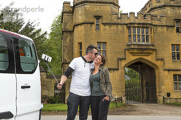 Ein Paar in einem Wohnmobil hält für ein Selfie vor dem Schloss Sudeley an; Winchcombe  England  UK