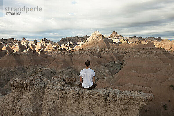 Ein Tourist genießt die Aussicht  während die Sonne den Badlands National Park beleuchtet; Badlands National Park  South Dakota