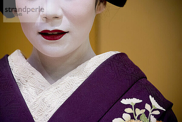 Porträt einer Maiko  einer Geisha-Lehrling in Kyoto und Westjapan. Ihre Arbeit besteht darin  bei Banketten und Festen für die Gäste Lieder und Tänze aufzuführen und auf dem Shamisen oder anderen traditionellen japanischen Instrumenten zu spielen. Maiko sind in der Regel zwischen 17 und 20 Jahre alt und erlangen nach einer gewissen Ausbildungszeit den Status einer Geisha. Diese Ausbildung dauert in der Regel einige Monate bis zu einem Jahr oder zwei Jahren  wobei Lehrlinge  die zu alt sind  um sich als Maiko zu kleiden  trotz ihrer Ausbildung die Stufe der Geisha überspringen können; Kyoto  Japan