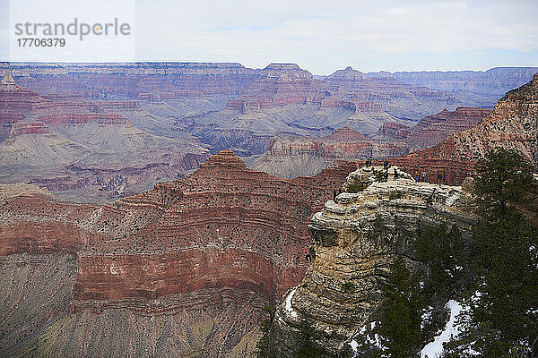 Weitwinklige Landschaft des Grand Canyon mit wenig Schnee und Touristen  die sich auf einem Felsvorsprung unterhalten; Arizona  Vereinigte Staaten von Amerika